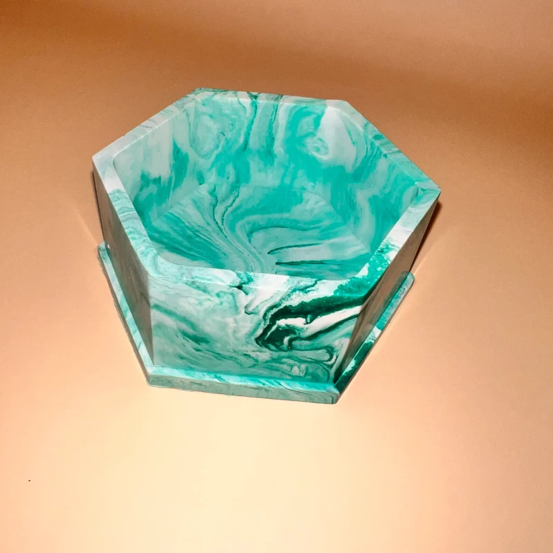 A Small Jesmonite green hexagonal holder with multiple decorative functions